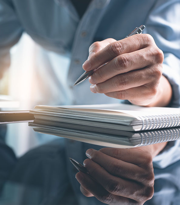 hand writing notes on a pad