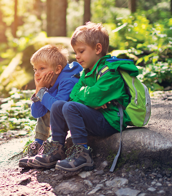 two little boys sitting in the woods two little boys sitting in the woods